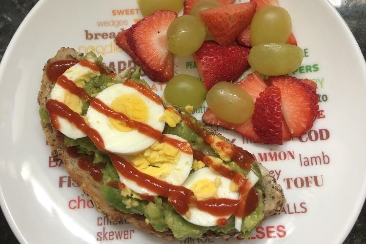 Sourdough Toast with Egg, Guacamole and Hot Sauce with a Side of Fruit